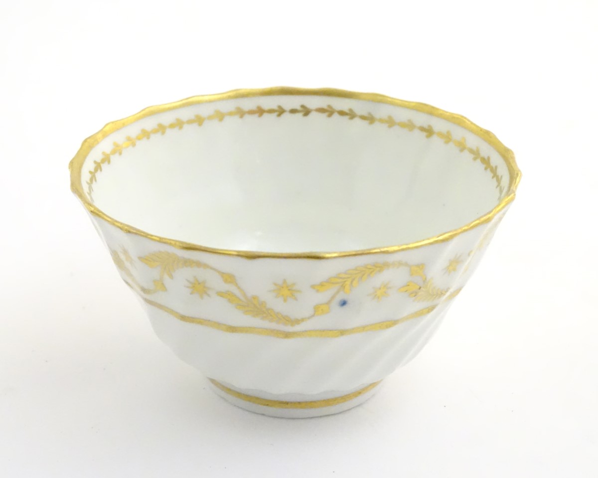 A 19thC white porcelain tea bowl with ribbed sides and gilt decoration of stylised foliage and - Image 3 of 7