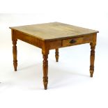 A late 19thC pine kitchen table with a single short drawer to one end and raised on turned tapering