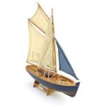 Toy: A wooden model boat / pond yacht with sails and a stand, entitled The Prawner. Approx.