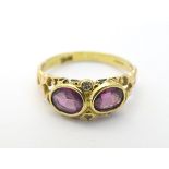 An 14ct gold ring set with 2 almandine garnets flanked by 2 diamonds CONDITION: