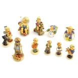 A collection of 9 Hummel Goebel figures of children playing.