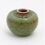A small Chinese brush washer of circular form in a mottled green and pink glaze.