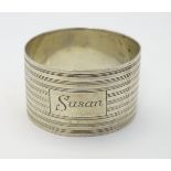 An Art Deco silver napkin ring with banded decoration.
