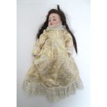 Toy: A French Limoges doll with a bisque head, blinking eyes, painted features and brown hair.