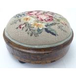 A late 19thC walnut footstool with a needlework upholstered top and inlaid base,