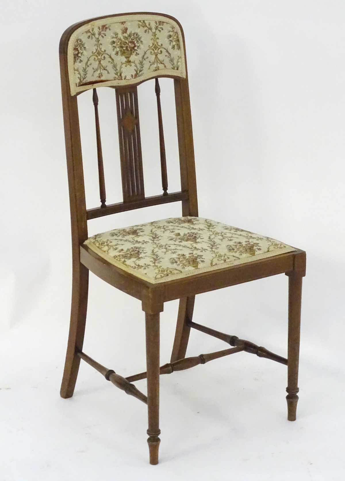 An early 20thC mahogany bedroom chair with a slatted backrest and inlaid decoration,