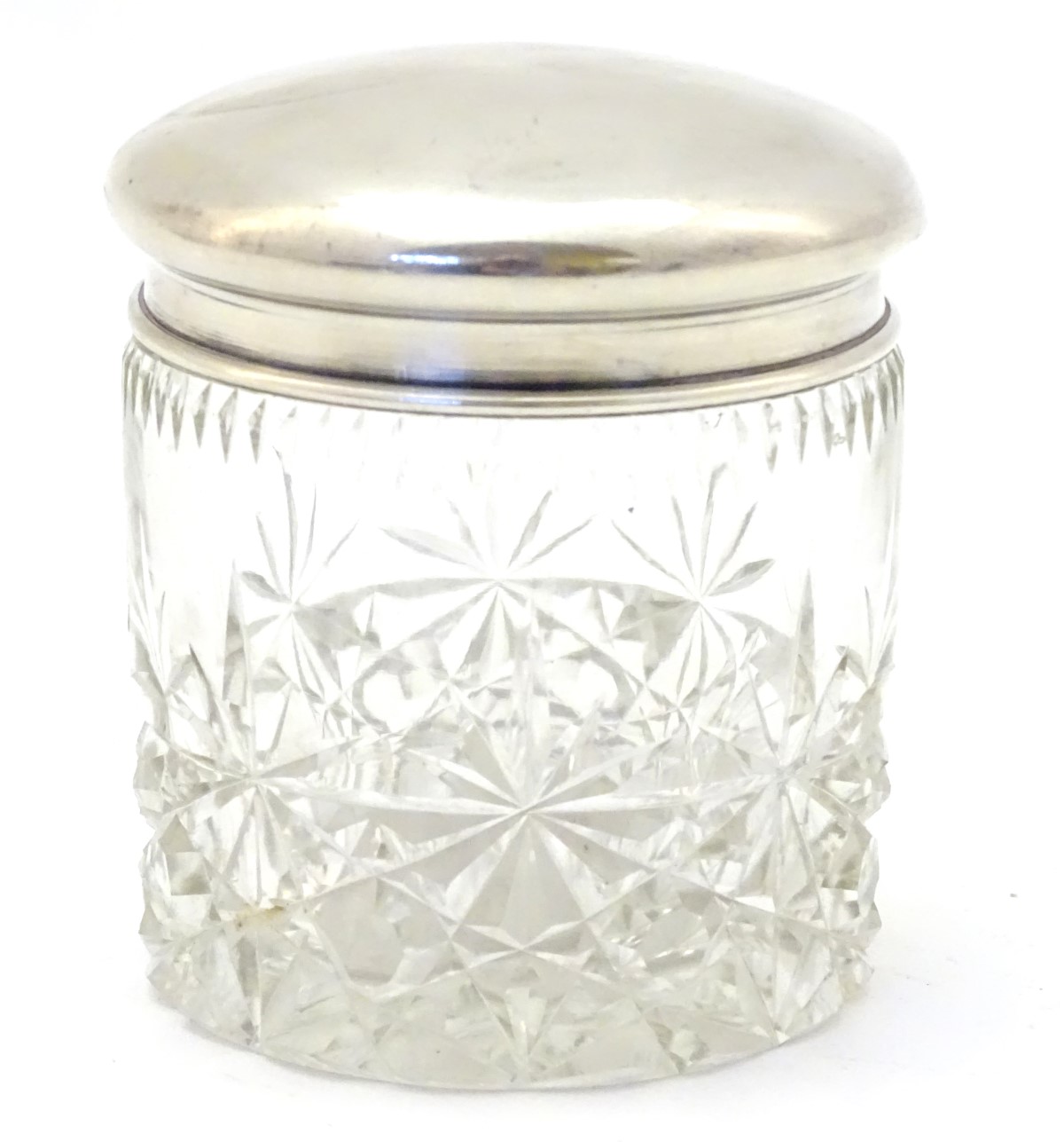 A cut glass dressing table jar with silver top hallmarked Birmingham 1924 maker Sanders & Mackenzie.