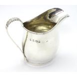 A silver cream jug with acanthus detail to handle, hallmarked Birmingham 1912,