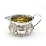 A Victorian silver cream jug with embossed decoration hallmarked Birmingham 1893 maker George
