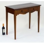 An early 20thC mahogany side table with a flame mahogany veneered top above two short drawers and a