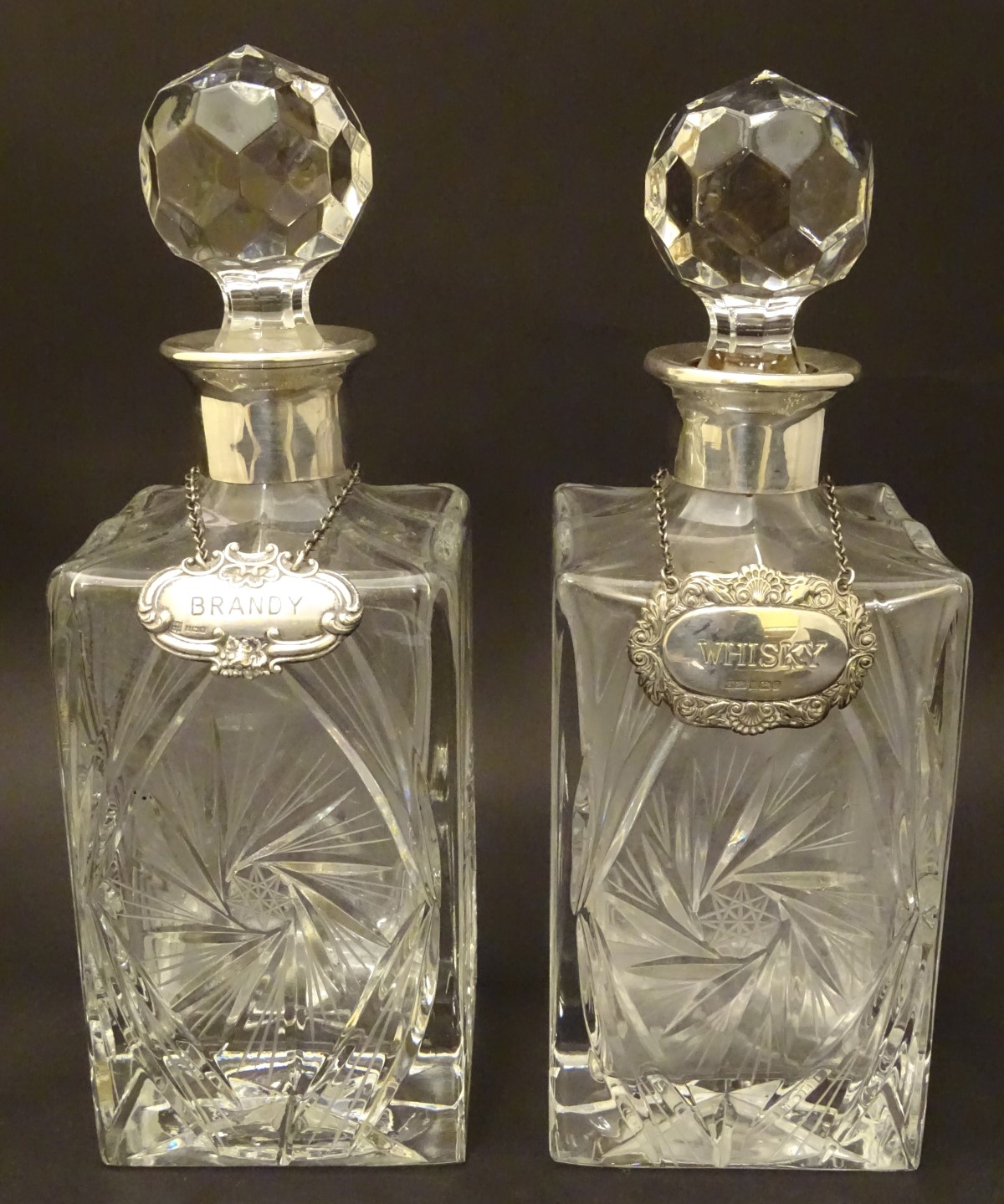 A pair of lead crystal decanters of squared form with mounted with silver collars,