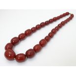 A Vintage necklace of graduated cherry amber coloured beads approx 24" long.