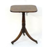 A late Georgian mahogany occasional table with a turned pedestal base above three sabre legs