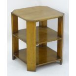 An Art Deco oak three tier table with four chamfered corner supports.