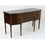An early 19thC mahogany sideboard with two central drawers and ebonised decoration flanked by deep