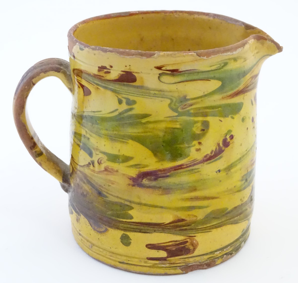 A 19thC studio pottery slipware jug with a yellow ground. Indistinct incised mark under. Approx.