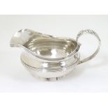 A silver jug / sauce boat with floral decoration to handle hallmarked London 1826 maker William