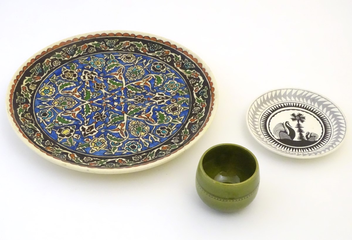 Three assorted ceramic items to include a charger with hand painted arabesque floral decoration,