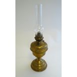 A 20thC oil lamp the brass stand with scroll decoration,