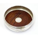 A silver wine / bottle coaster with turned wooden base 5 1/4" wide CONDITION: Please