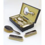 A cased dressing table set comprising silver backed brushes and mirror,