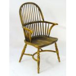 A 20thC double bow beech Windsor chair with a shaped seat above turned legs and a crinoline