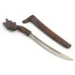 Ethnographic / Native / Tribal : A tribal dagger with a wooden handle terminating with carved