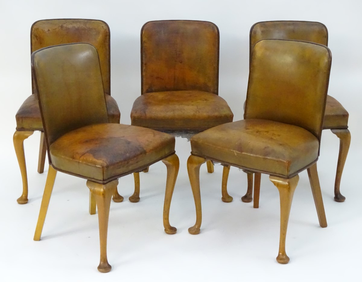 A set of five Art Deco leather upholstered chairs with curved backrests,