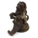 A late 19th / early 20thC cast bronze heraldic sejant lion with a scrolling shield / cartouche.