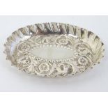 A Victorian silver pin tray with embossed decoration hallmarked London 1883 maker Holland,