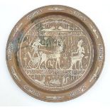 An Egyptian revival copper charger with white metal inlay decoration depicting 2 figures and a