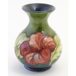 A Moorcroft vase with tube lined hibiscus flower decoration.