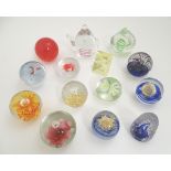 Thirteen assorted art glass paperweights, including one formed as a teapot, approx. 5" high.