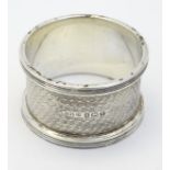 An Art Deco silver napkin ring with engine turned decoration.