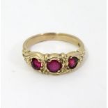 A yellow metal ring set with graduated rubies.