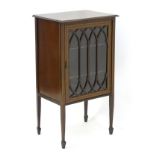 An Edwardian mahogany display cabinet with a small glazed door having inlaid decoration and Gothic