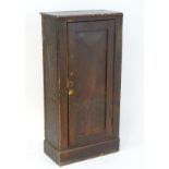 An early 20thC pine cupboard with a moulded rectangular top above a chamfered door opening to
