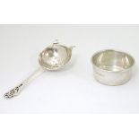 A silver tea strainer and stand / bowl.