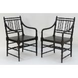 A pair of ebonised open armchairs in the manner of Howard Webb with a faux bamboo design.