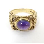 A 9ct gold retro ring set with central amethyst cabochon CONDITION: Please Note -