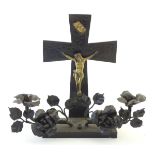 A 20thC crucifix candelabra with Christ on the cross and candle holders formed as flowers.