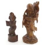 An Oriental carved wooden figure depicting an elder / sage.