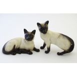 Two Beswick siamese cats, one standing and one recumbent, model numbers 1897 and 1559, respectively.