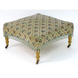 An early 20thC footstool with an upholstered sprung top and concave sides,