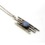 A modernist silver pendant set with opal cabochon,