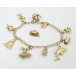 A 9ct gold charm bracelet set with various 9ct gold and yellow metal charms CONDITION: