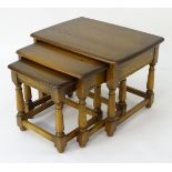 A 21stC ash nest of three tables by Ercol, with inspection label and gold tree roundel insert,