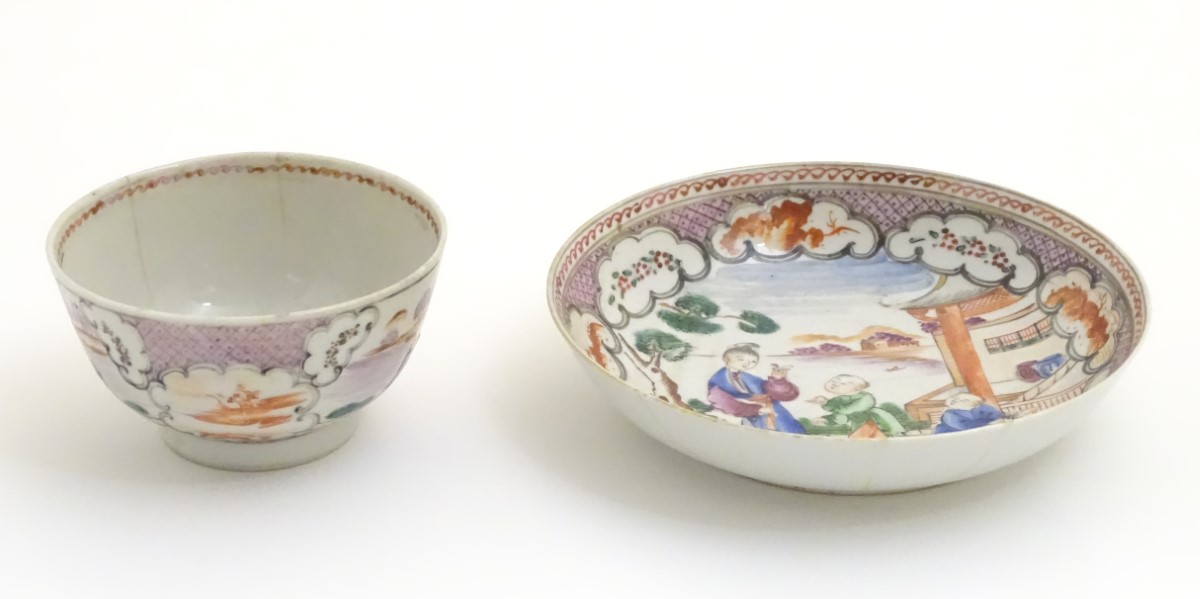 A Chinese famille rose tea bowl and saucer with hand painted decoration depicting figures on a