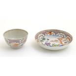 A Chinese famille rose tea bowl and saucer with hand painted decoration depicting figures on a