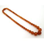 A vintage bead necklace of graduated amber coloured beads.